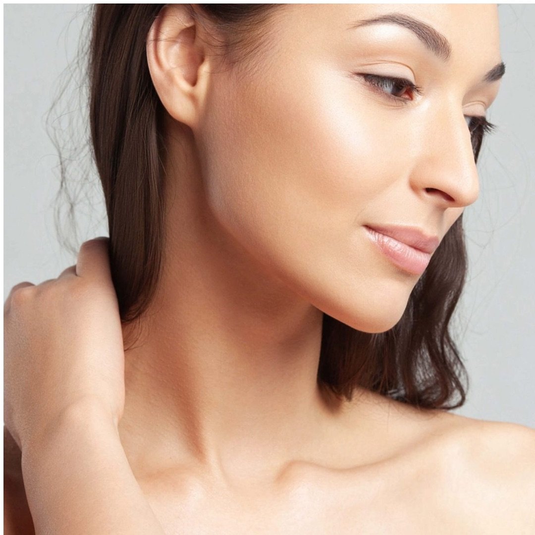 profile of a woman with an elegant nasal structure and balanced facial contours, looking downward against a neutral background.